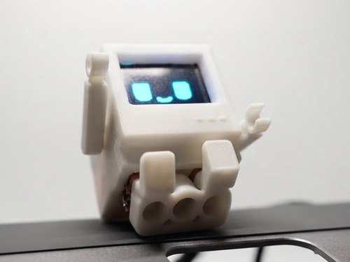 3D-printed desk robot with animated eyes on a screen